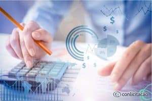 Mulher utilizando calculadora e computador. Imagem ilustrativa para texto Como calcular preço inexequível em licitação.