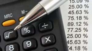 Imagem de calculadora e caneta. Ilustrativa para texto Margem de lucro licitação.