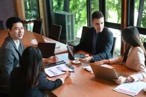 Consultoria em licitação: equipe analisa gráficos e documentos em reunião estratégica, com foco em propostas para o setor público.